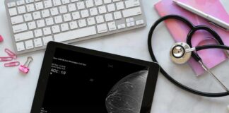 A tablet displaying a mammogram image on a desk with medical tools