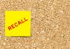 Yellow sticky note with the word 'RECALL' on a corkboard