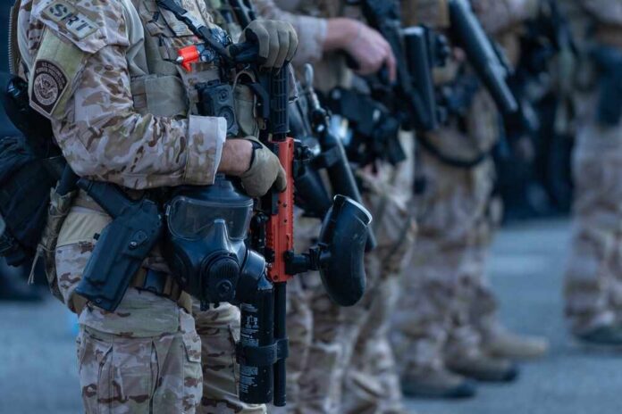 Law enforcement officers in tactical gear holding weapons