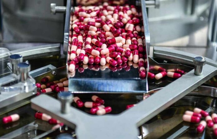 Capsules being processed on a conveyor in a pharmaceutical facility