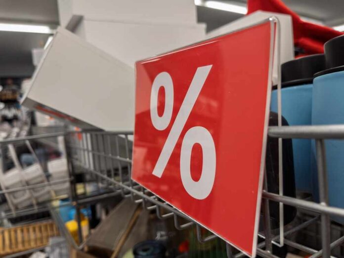 Red discount sign with a percentage symbol in a retail setting