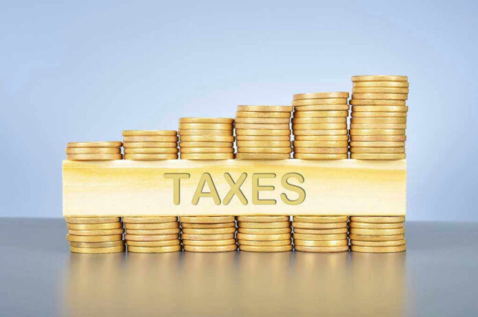 Stacked coins with TAXES on block beneath.