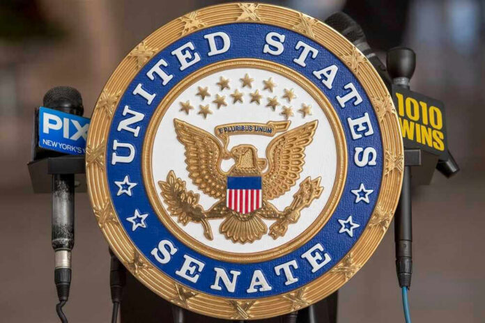 United States Senate seal with microphones in front.