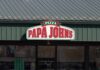 Exterior view of a Papa John's pizza restaurant with a green roof