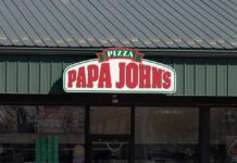 Exterior view of a Papa John's pizza restaurant with a green roof
