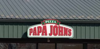 Exterior view of a Papa John's pizza restaurant with a green roof