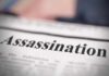 Close-up of a newspaper headline reading 'Assassination'
