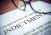 Close-up of an indictment document with glasses resting on it