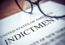 Close-up of an indictment document with glasses resting on it