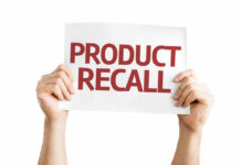 Hands holding a sign that reads 'PRODUCT RECALL'