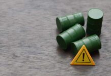 Gulf Oil Exports SEVERED — Modern History’s Worst Four green barrels and a warning sign on a wooden surface