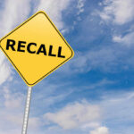 RECALL: 10 MILLION YANKED OFF SHELVES Yellow sign with RECALL text against blue sky.