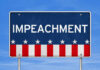 Sign displaying the word 'IMPEACHMENT' with a patriotic design
