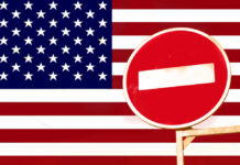 A no entry sign in front of the American flag