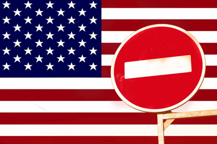 shutterstock_700870216.jpg A no entry sign in front of the American flag