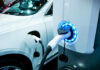 EV Gamble COSTS Billions – First Loss in 70 Years! Electric vehicle charging at a station, close-up view.