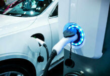 Electric vehicle charging at a station, close-up view.