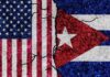 Cracked flags of the United States and Cuba on a textured surface