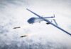Military drone releasing missiles in the sky