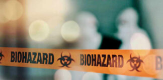 Biohazard tape with blurred figures in background.