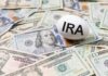 An egg labeled 'IRA' placed on a pile of U.S. dollar bills