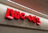 Bright red Buc-ee's store sign on a wall