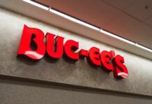 Bright red Buc-ee's store sign on a wall