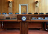 Empty Senate chamber with a wooden podium and chairs