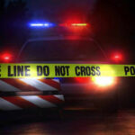 Gunfight Erupts Outside Courthouse Police car with flashing lights behind caution tape.