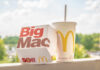 A Big Mac box next to a McDonald's drink cup on a ledge