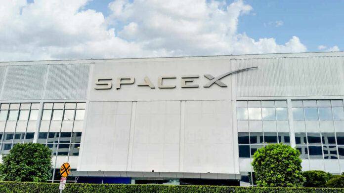 SpaceX building with logo and blue sky.
