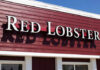 Signage of Red Lobster restaurant against a blue sky