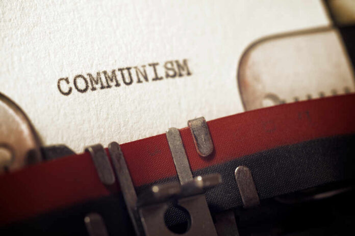 Close-up of a typewriter with the word 'COMMUNISM' typed on paper