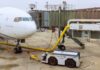 Airplane parked at the gate with boarding bridge and ground equipment