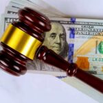 UPDATE: Judge Nukes Trump’s $100K Visa Grab Judge’s gavel on a stack of U.S. hundred-dollar bills