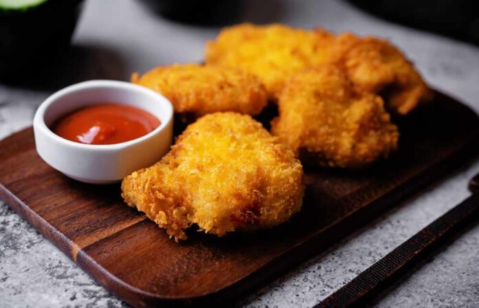 Crispy fried chicken pieces served with a small bowl of ketchup