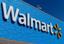 Walmart Price Drop Sparks Credit Brawl Walmart store sign on a blue wall