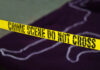 Yellow crime scene tape marking off an area with a chalk outline