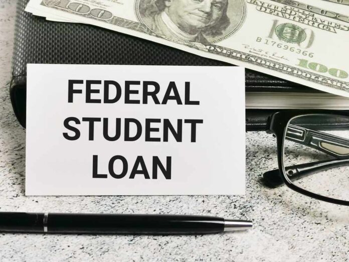 White,Card,With,Text,Federal,Student,Loan,With,A,Pen A sign reading 'Federal Student Loan' next to a stack of money and a pen