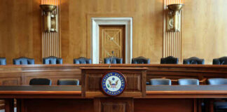 Empty Senate chamber with a wooden podium and chairs
