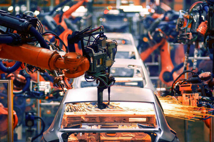 shutterstock_732734518 Robotic arms welding car bodies in an automotive factory.