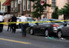 Police and crime scene tape on city street.