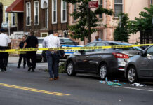 Police and crime scene tape on city street.