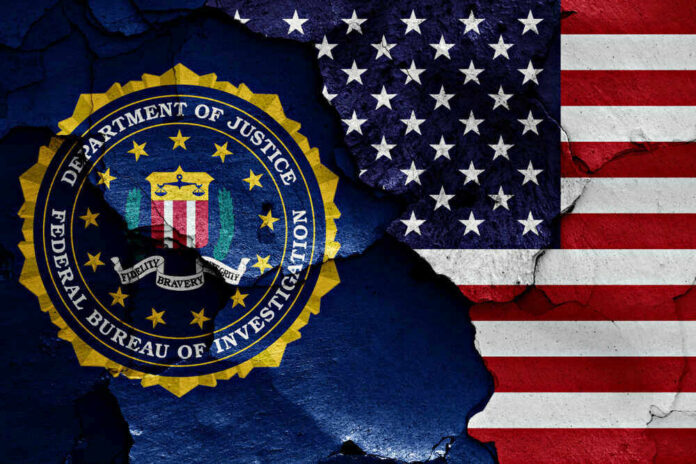 shutterstock_1023380488 FBI seal superimposed on cracked American flag.