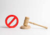 Wooden judge's gavel beside a red prohibition symbol