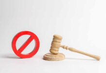 Wooden judge's gavel beside a red prohibition symbol