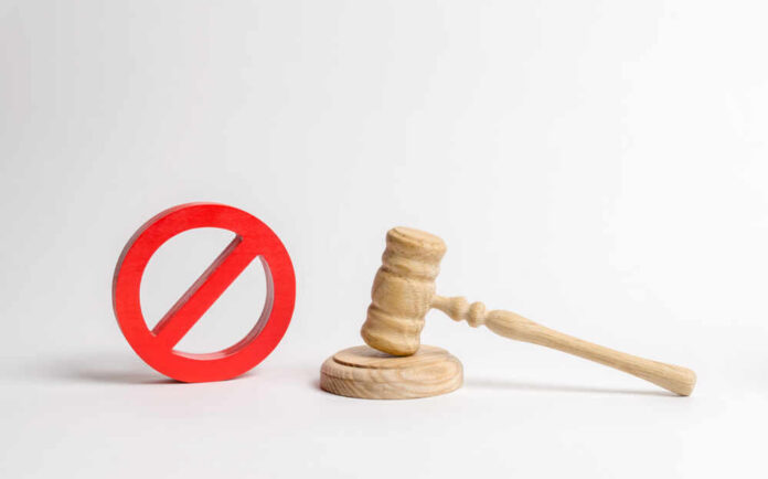 Wooden judge's gavel beside a red prohibition symbol