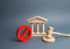 Wooden courthouse with red prohibition symbol and judge’s gavel