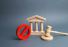 Wooden courthouse with red prohibition symbol and judge’s gavel