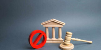 Wooden courthouse with red prohibition symbol and judge’s gavel